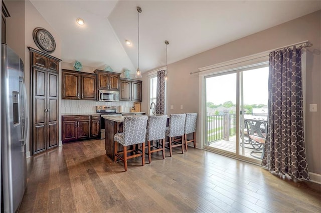 kitchen featuring a breakfast bar, hardwood / wood-style floors, and stainless steel appliances