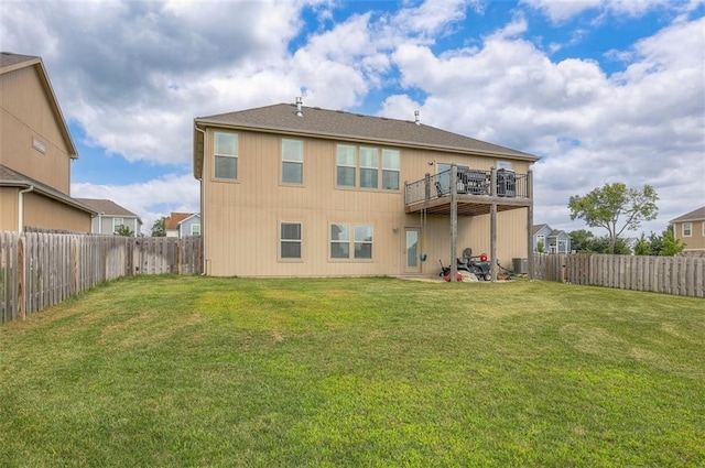 rear view of house with a deck and a lawn