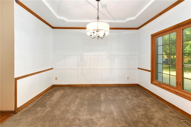 empty room with a tray ceiling, carpet floors, and an inviting chandelier