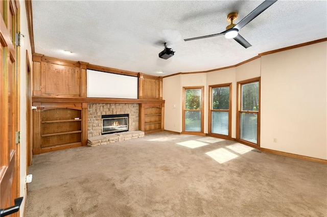 unfurnished living room featuring ceiling fan, light carpet, a textured ceiling, and a stone fireplace