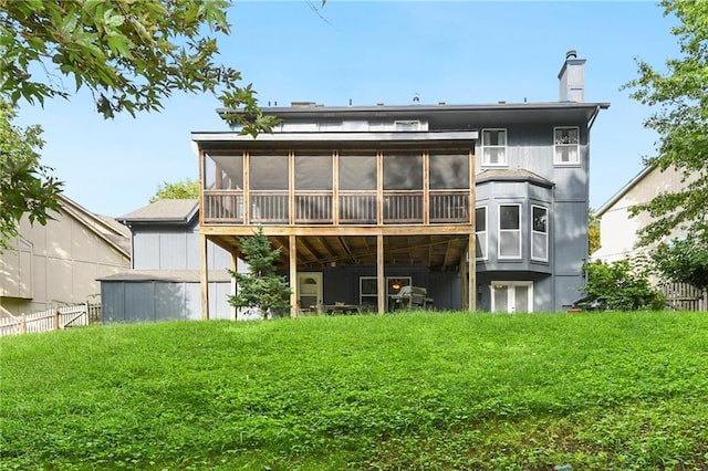 rear view of house with a sunroom and a lawn