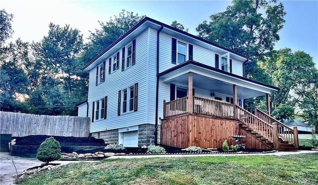 view of front facade featuring stairs, a front yard, an attached garage, and fence