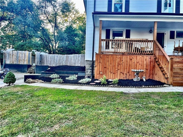 view of home's exterior featuring stairway, a lawn, a porch, and fence