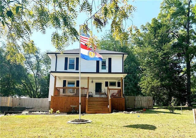 view of front of home with a porch, fence, and a front yard