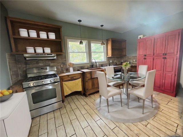 kitchen with tasteful backsplash, under cabinet range hood, gas range, light wood-style flooring, and open shelves