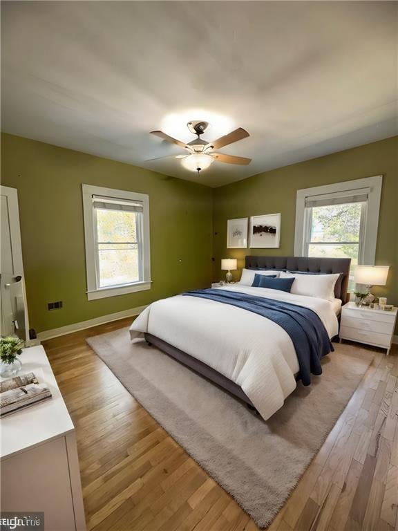 bedroom featuring light wood-style flooring, multiple windows, baseboards, and ceiling fan