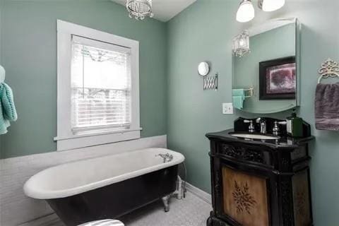 bathroom featuring vanity, baseboards, and a freestanding tub