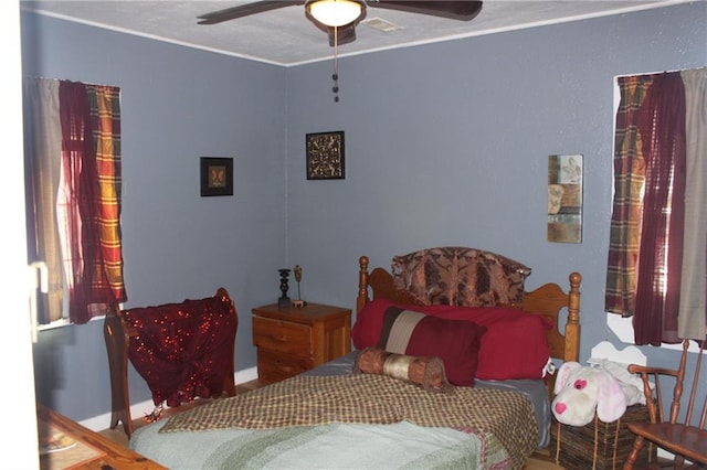 bedroom with ceiling fan and crown molding