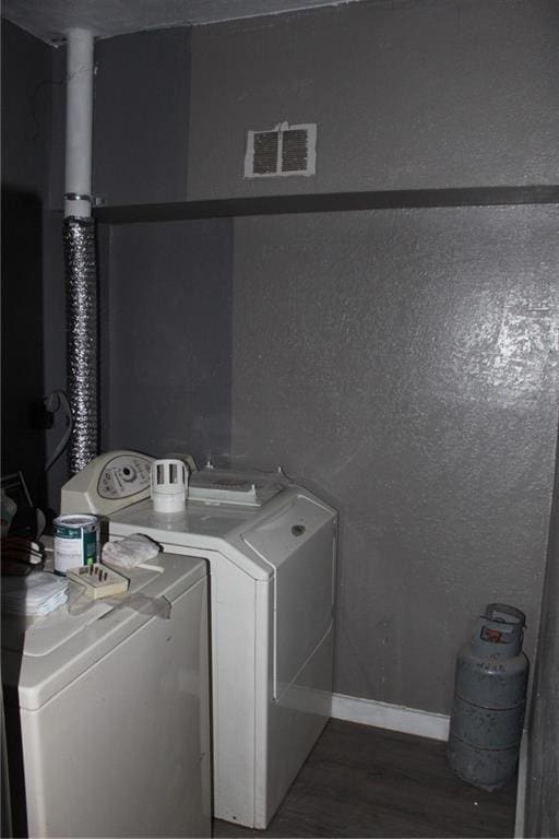 washroom with washer and dryer and dark wood-type flooring