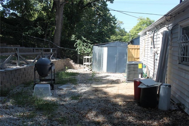 view of yard featuring a shed and central air condition unit