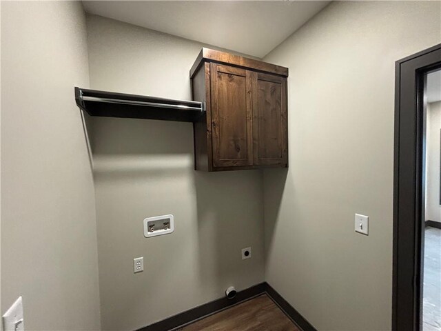 washroom featuring wood-type flooring, hookup for an electric dryer, washer hookup, and cabinets