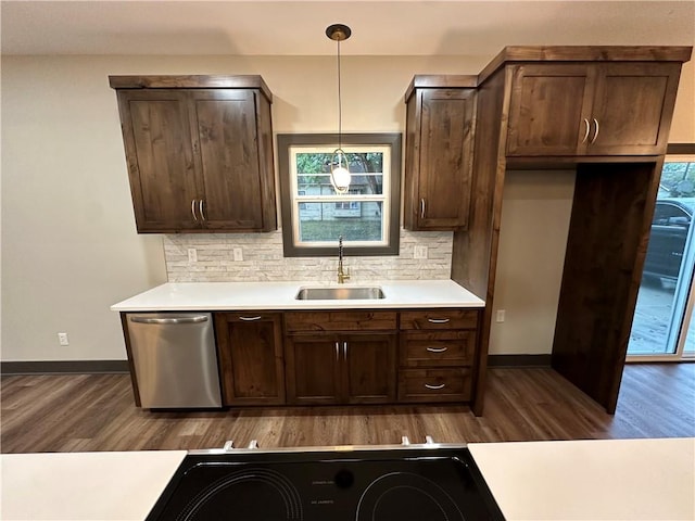 kitchen featuring tasteful backsplash, decorative light fixtures, stainless steel dishwasher, dark hardwood / wood-style floors, and sink