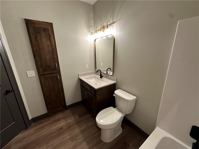 bathroom with vanity, hardwood / wood-style flooring, and toilet