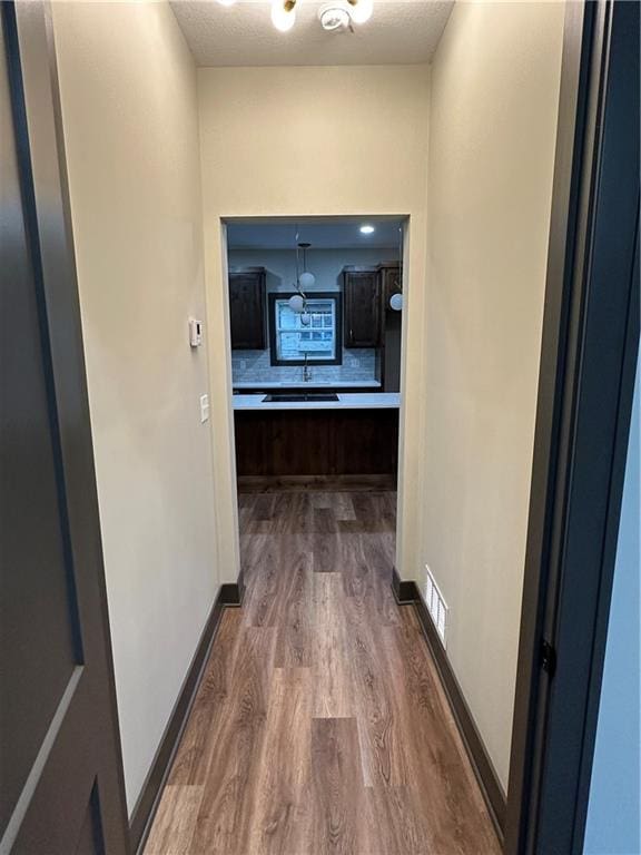 hallway featuring hardwood / wood-style flooring and a textured ceiling