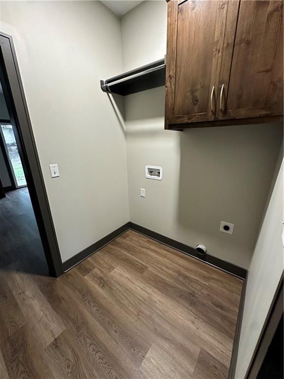 washroom with cabinets, wood-type flooring, hookup for an electric dryer, and hookup for a washing machine