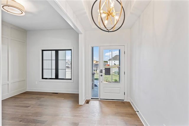 entryway with light hardwood / wood-style floors and a chandelier