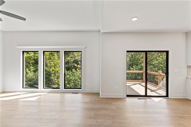 empty room with light hardwood / wood-style floors, ceiling fan, and plenty of natural light