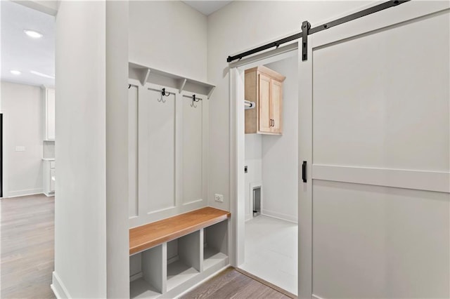 mudroom featuring light wood-type flooring and a barn door