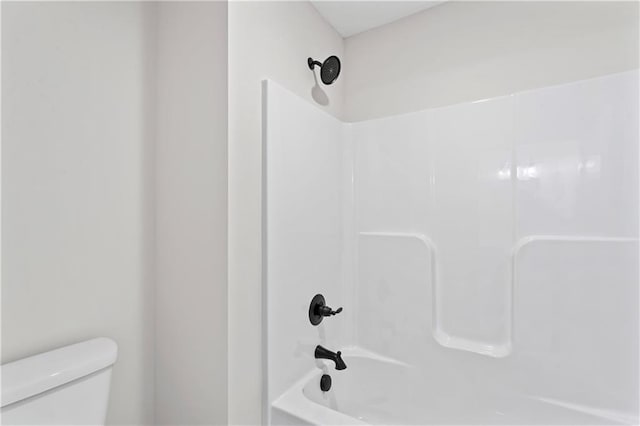 bathroom featuring toilet and washtub / shower combination