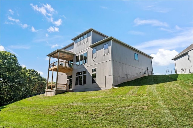 back of property with a lawn and a balcony