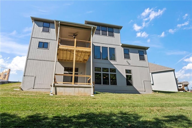 rear view of house featuring a balcony, ceiling fan, and a yard