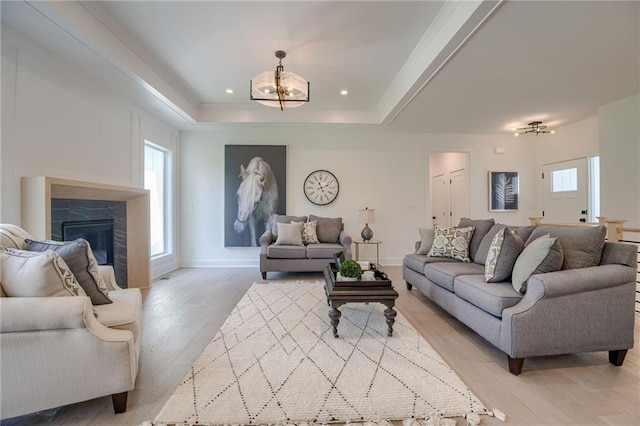 4805 NE 62nd St, Kansas City, MO 64119 - living room with plenty of natural light, a chandelier, light wood-style flooring, and a glass covered fireplace
