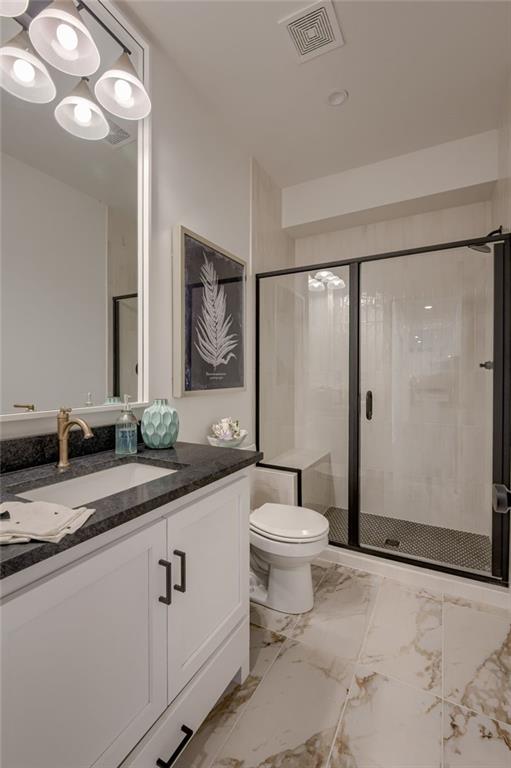 4805 NE 62nd St, Kansas City, MO 64119 - full bath with vanity, a stall shower, and marble finish floors