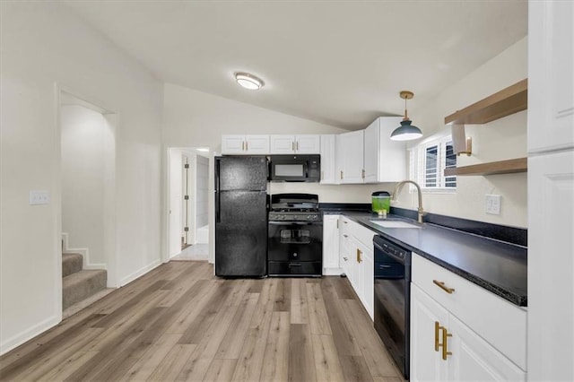 kitchen featuring light hardwood / wood-style flooring, sink, black appliances, vaulted ceiling, and white cabinets