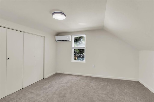 additional living space featuring lofted ceiling, a wall mounted AC, and light carpet