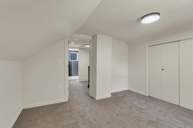 bonus room with light carpet and lofted ceiling