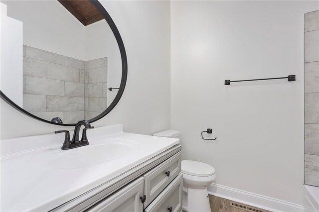 bathroom featuring toilet, vanity, and wood-type flooring