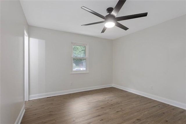 empty room with ceiling fan, baseboards, and wood finished floors