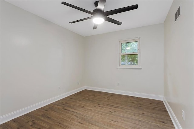 unfurnished room with a ceiling fan, visible vents, wood finished floors, and baseboards