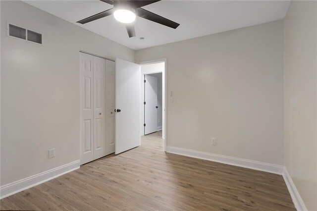 empty room with ceiling fan and light hardwood / wood-style floors