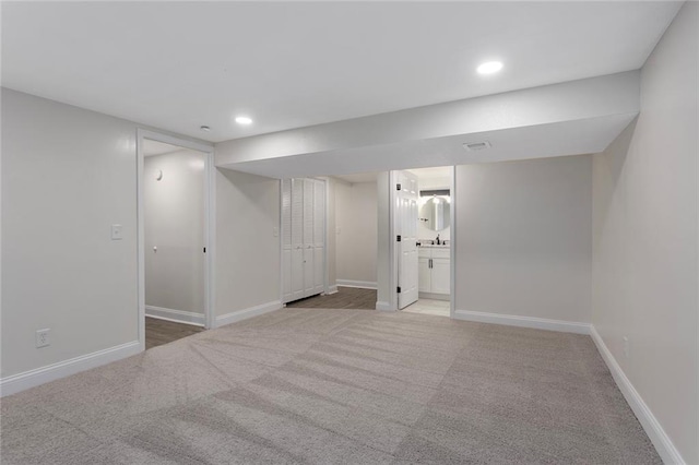 finished basement featuring recessed lighting, baseboards, and light carpet