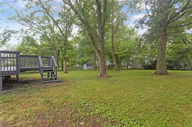 view of yard with an outbuilding, a deck, and a shed