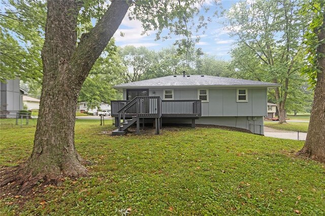 rear view of house featuring a deck and a yard