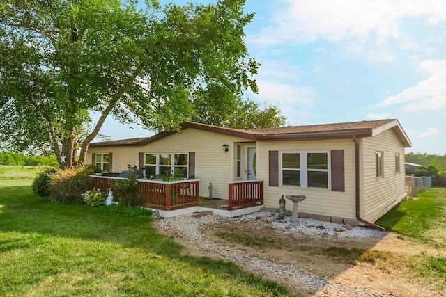 rear view of property featuring a deck and a yard