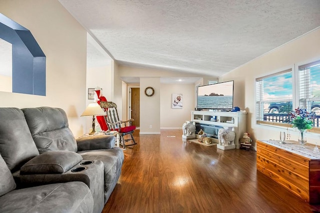 living room featuring a textured ceiling, vaulted ceiling, and hardwood / wood-style flooring