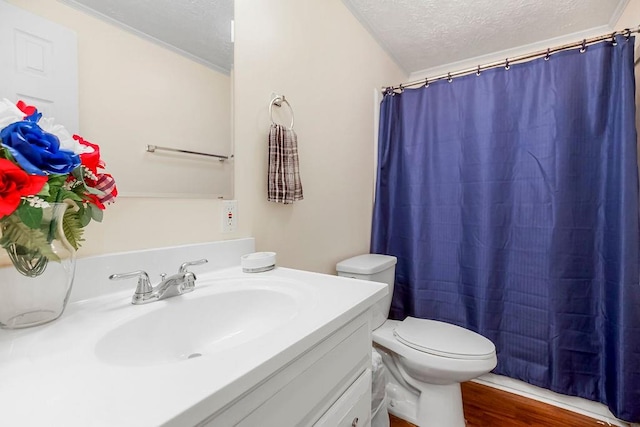 bathroom with a textured ceiling, vanity, hardwood / wood-style floors, and toilet