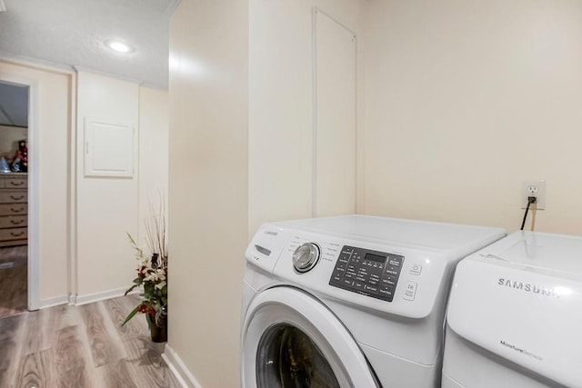 laundry room featuring washing machine and dryer and light wood-type flooring