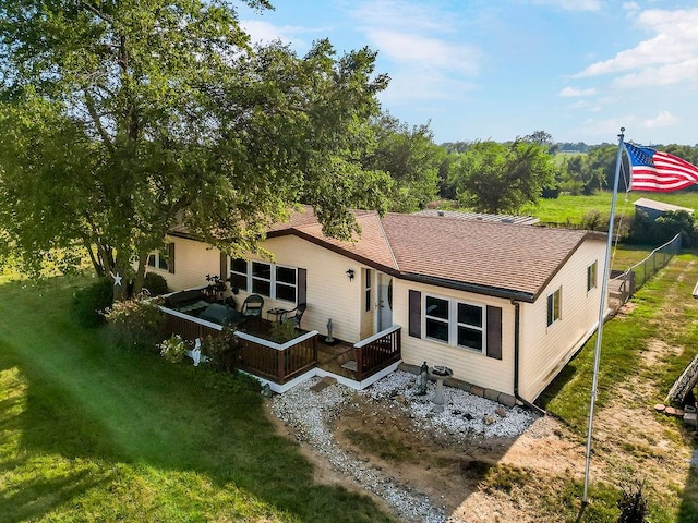 back of house with a deck and a yard