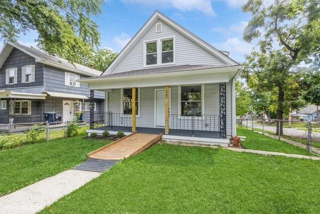 bungalow featuring a porch, fence, and a front lawn