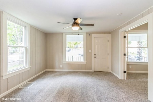 carpeted spare room featuring ceiling fan