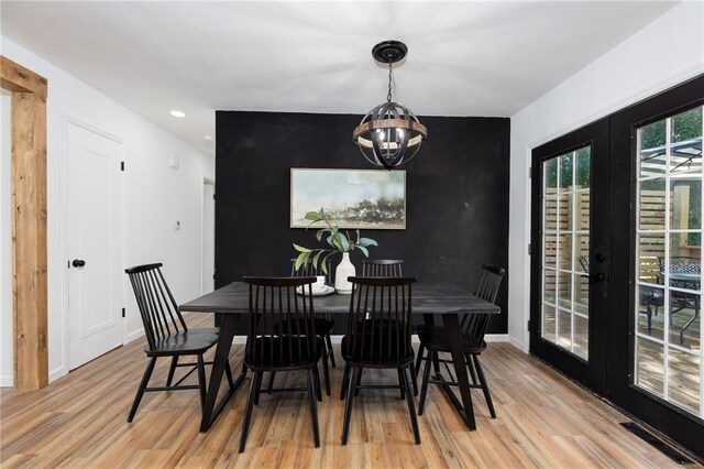 dining room with light hardwood / wood-style floors, french doors, and a chandelier