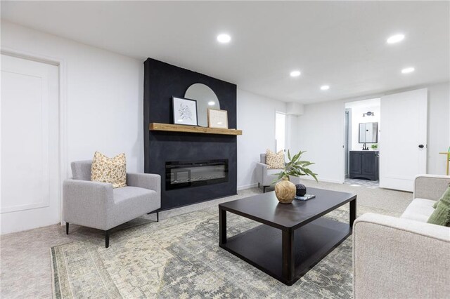 carpeted living room with a large fireplace