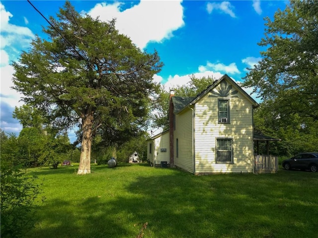 view of side of property featuring a yard and a chimney