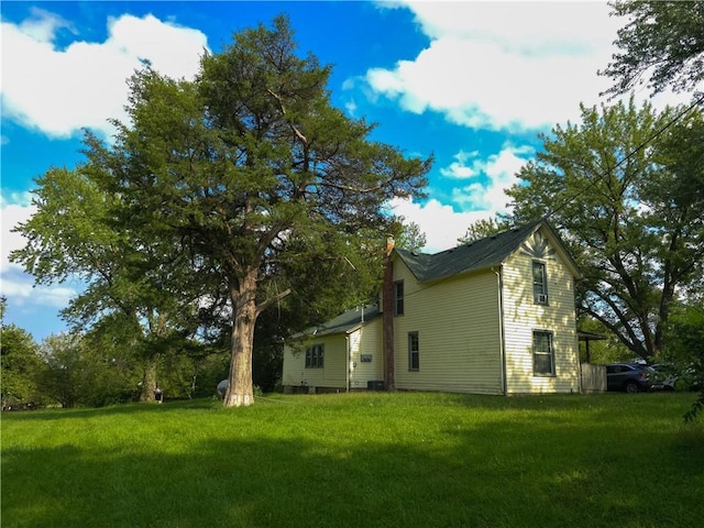 view of side of home featuring a yard and central air condition unit