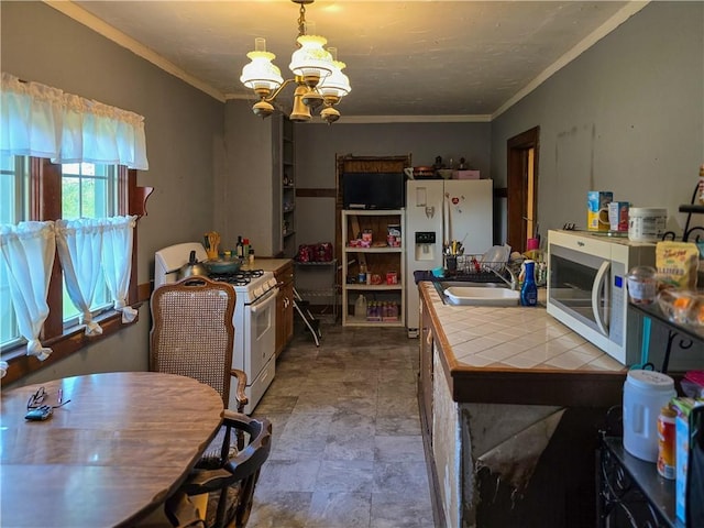 kitchen with decorative light fixtures, crown molding, tile countertops, a chandelier, and white appliances