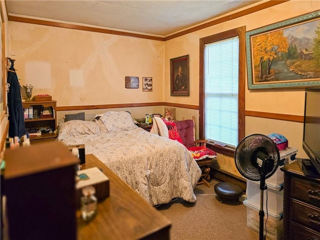 bedroom featuring ornamental molding and carpet